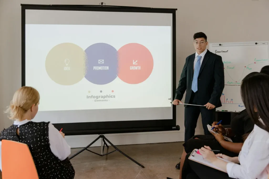 Profesional mempresentasikan pitch deck dengan infografis di layar proyektor dalam rapat bisnis