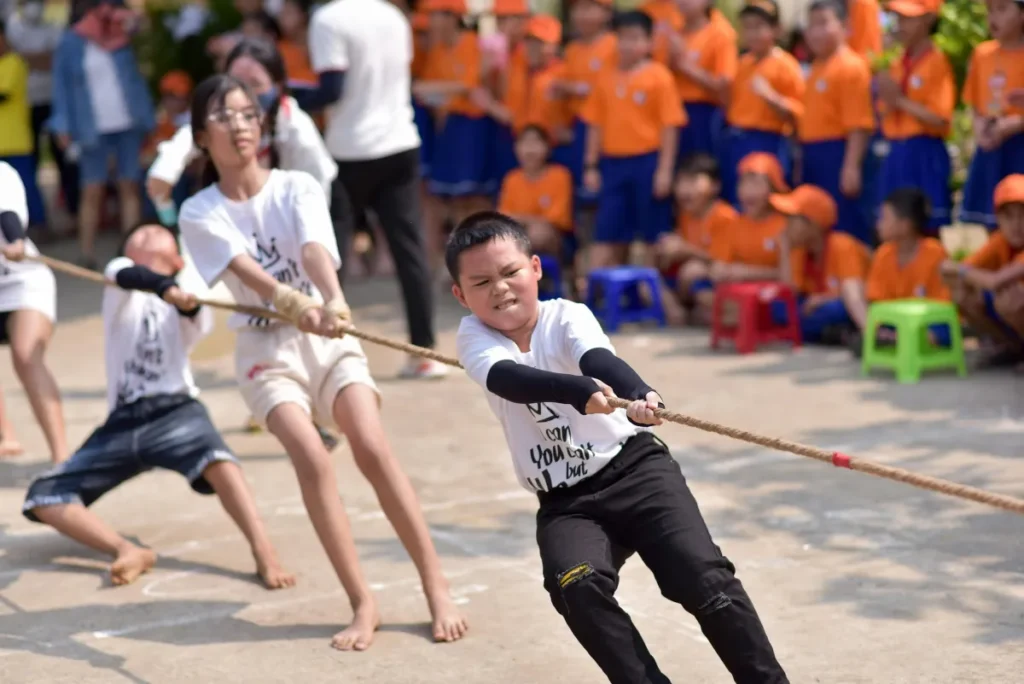 Anak-anak bermain tarik tambang di luar ruangan dalam acara lomba yang seru